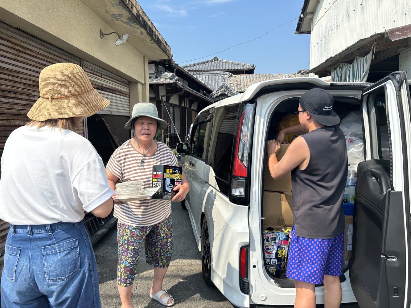 現地で、車から降ろした物資を手渡しているところ