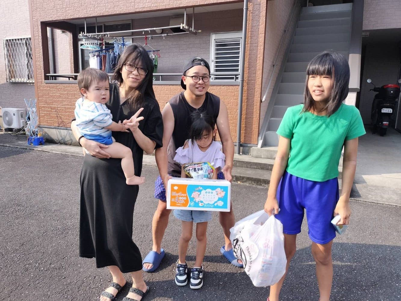 屋外で、お届けした品を持つご家族